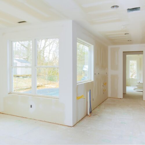 Interior construction of housing project with drywall installed and patched without painting applied